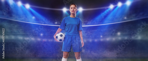  Portrait of young female soccer player with soccer ball standing in a big stadium.