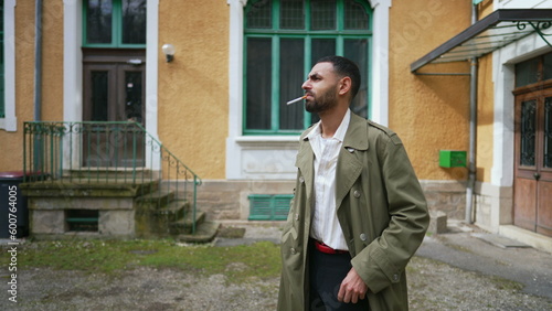 Wallpaper Mural One serious Arab man light a cigarette while standing outside with pensive emotion Torontodigital.ca