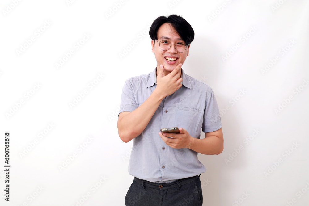 Happy asian man holding a cell phone while looking at the camera. Isolated on white Happy asian man holding a cell phone while looking at the camera. Isolated on white