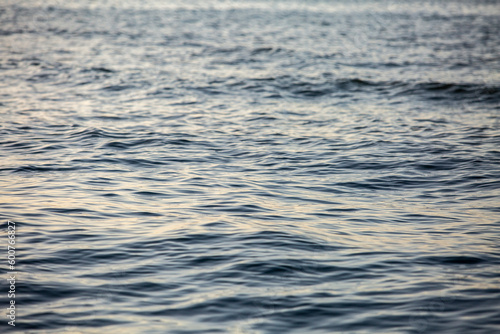 Close-up of water surface, dark waves on the sea during sunset