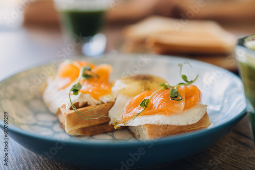 Waffles with egg, salmon and microgreens.Delicious and healthy breakfast food concept.Close-up,selective focus.