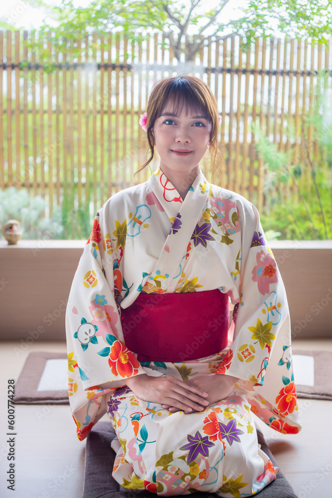 Young woman wearing Japanese traditional kimono in Japanese style house with garden background Young woman wearing Japanese traditional kimono in Japanese style house with garden background