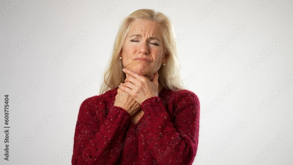 Mature middle age woman suffering from sore throat isolated on solid white background. Mature middle age woman suffering from sore throat isolated on solid white background.