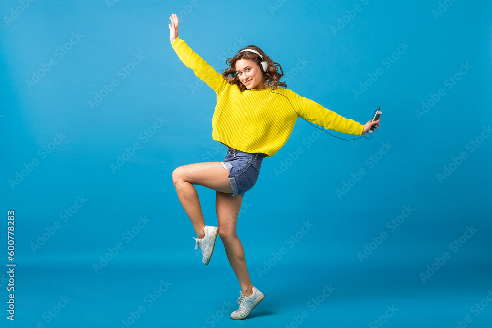 attractive woman in cheerful exited mood listening to music in headphones