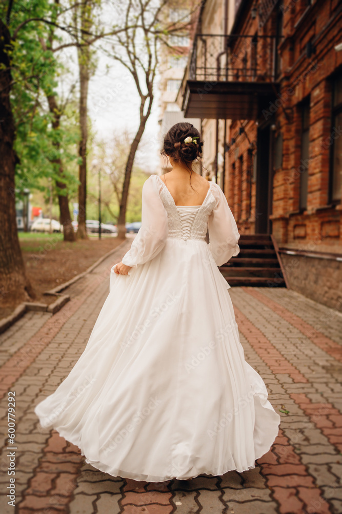 without a face. Rear view of a dark-haired woman in a wedding dress. 