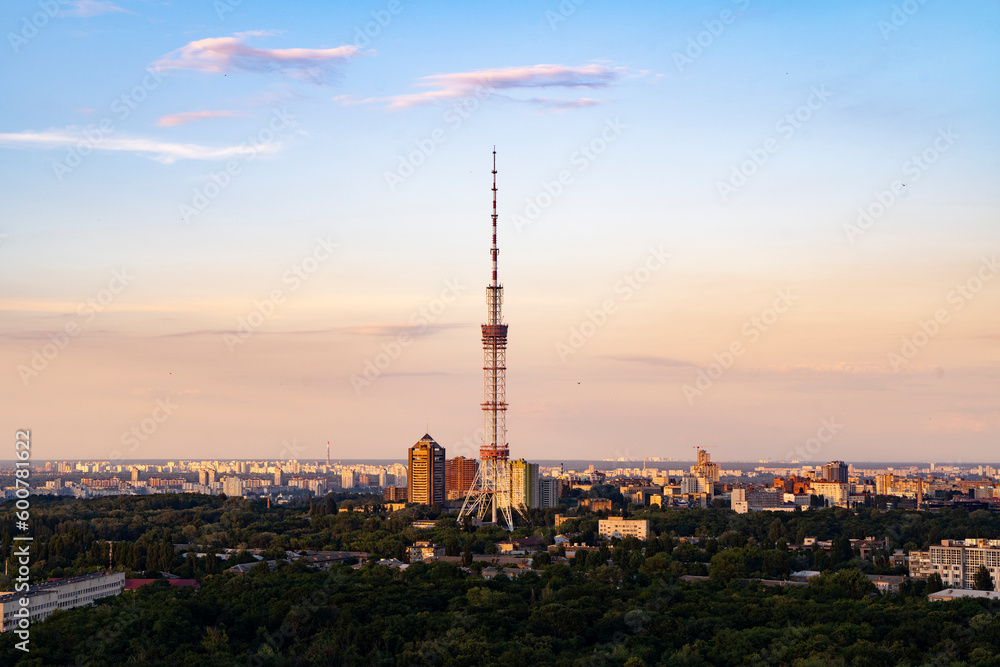 Incredible ruff top view on TV tower in Kyiv during sunset golden hour time with nice gradient sky color in not cloudy evening.