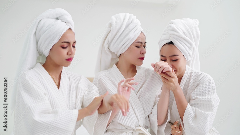 Group of young beautiful Asian woman in white bathrobe enjoy applies moisturizing cream to skin feeling fragrant smell. Skin care concepts Group of young beautiful Asian woman in white bathrobe enjoy applies moisturizing cream to skin feeling fragrant smell. Skin care concepts