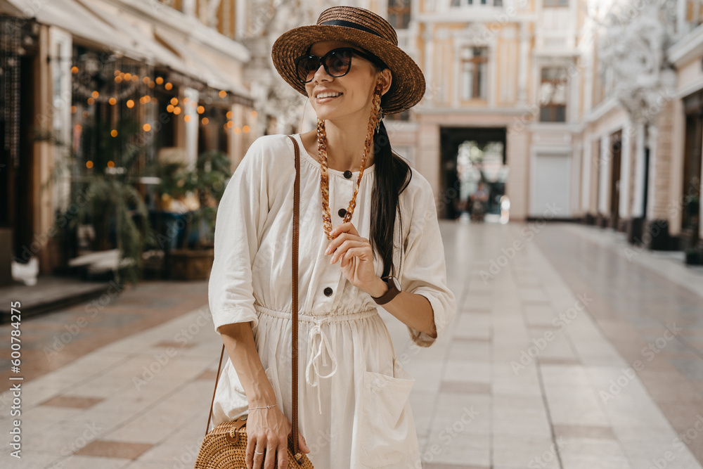 Obraz premium attractive woman walking in shopping street in Italy on vacation dressed in white summer fashion dress