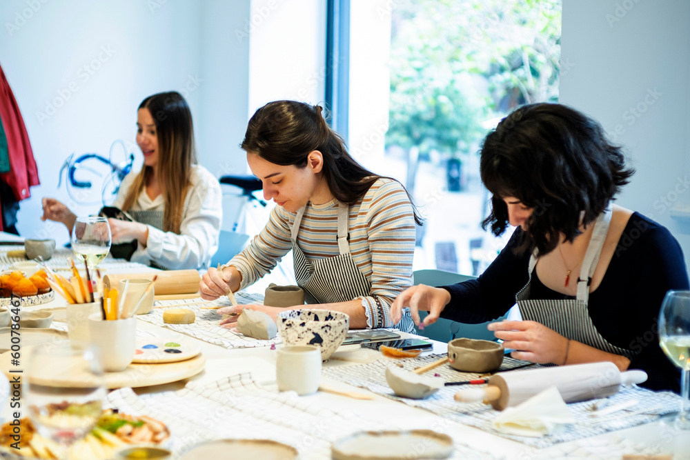 Cheerful women having pottery lesson in studio Cheerful women having pottery lesson in studio