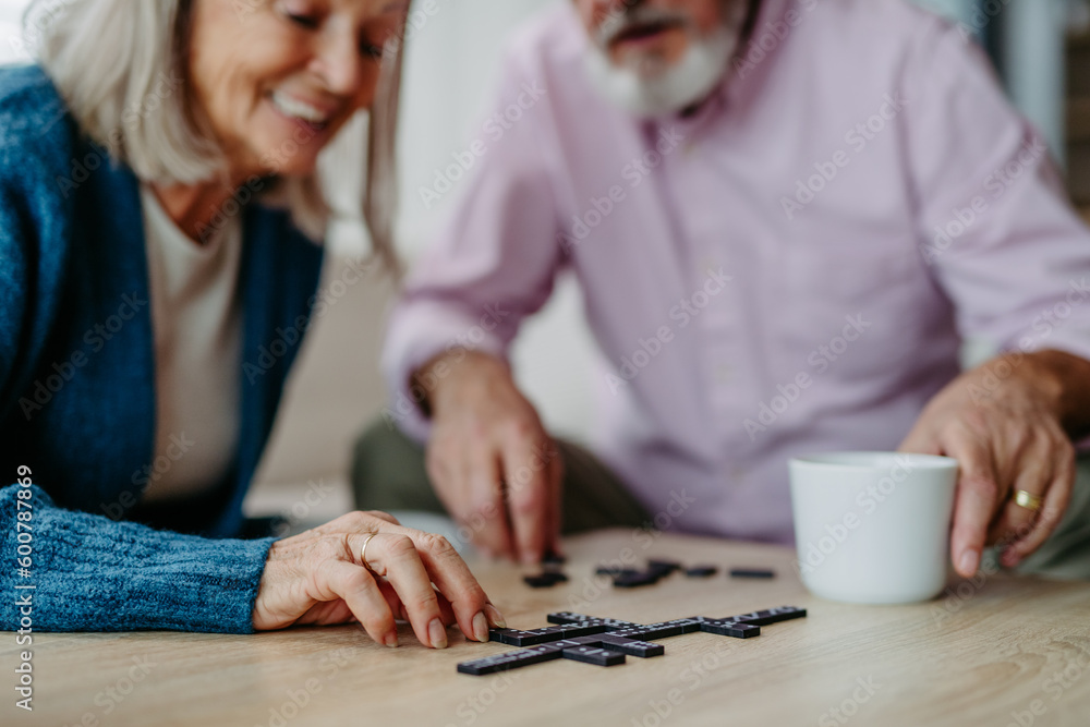 Senior couple playing dominoes game in their home. Senior couple playing dominoes game in their home.