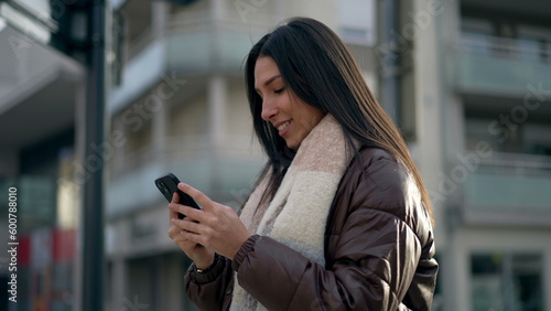 Wallpaper Mural Happy adult girl in 20s holding cellphone in city street. Tracking shot in motion of a young woman reading message on phone standing outside in urban setting Torontodigital.ca