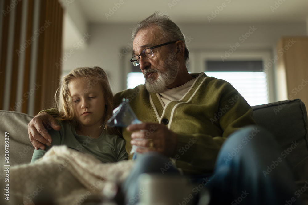 Fototapeta premium Senior man taking care of his sick granddaughter.