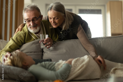 Grandparents taking care of their sick granddaughter. photo