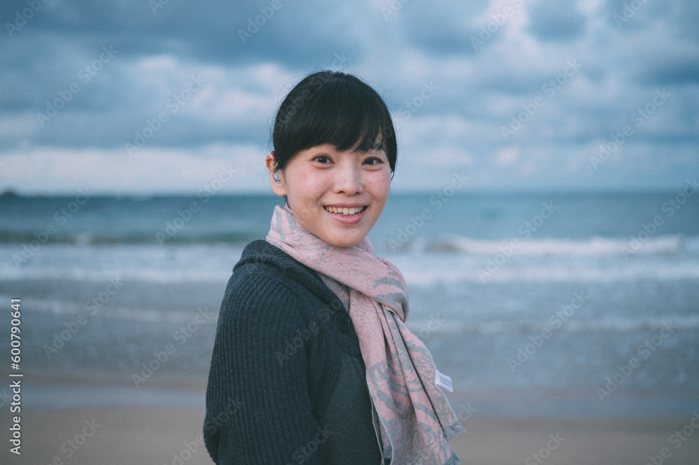 聴覚障害者の女性が海で微笑んでいる 聴覚障害者の女性が海で微笑んでいる