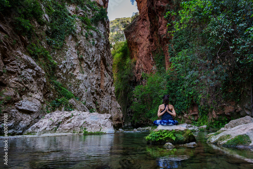 woman practicing yoga by the river, God's Bridge, Akchour, Talassemtane Nature Park, Rif region, morocco, africa