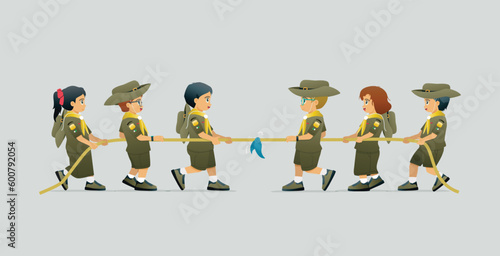 Students in scout uniforms doing tug of war against a gray background.
