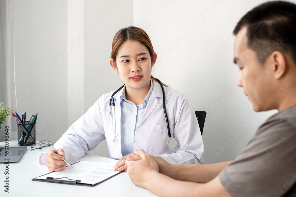 The doctor is explaining the treatment method to the male patient in the hospital.