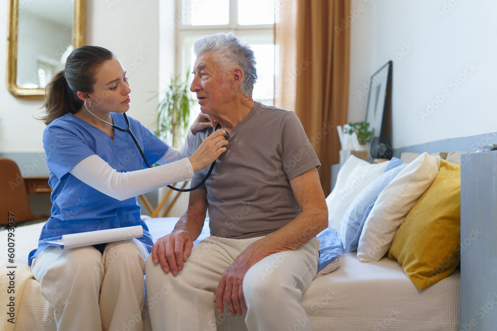 Obraz premium Young nurse checking elderly senior in his home.