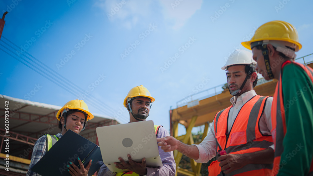Fototapeta premium Professional asian team, Male and female civil engineers manager or architects and foreman, worker. While meeting discuss inspect with laptop building project on construction site.