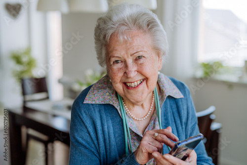 Portrait of happy senior woman with smartphone.