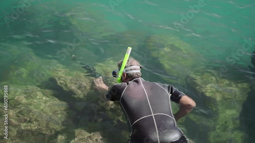 Unrecognizable man spearfishing with a speargun photo