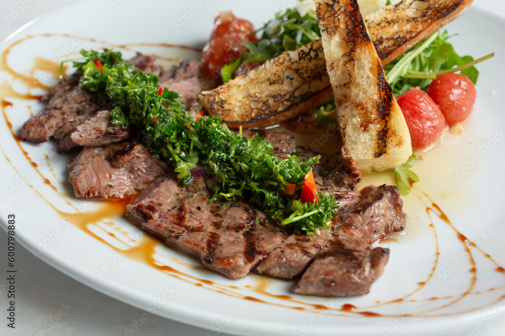 A view of a plate of steak and chimichurri.