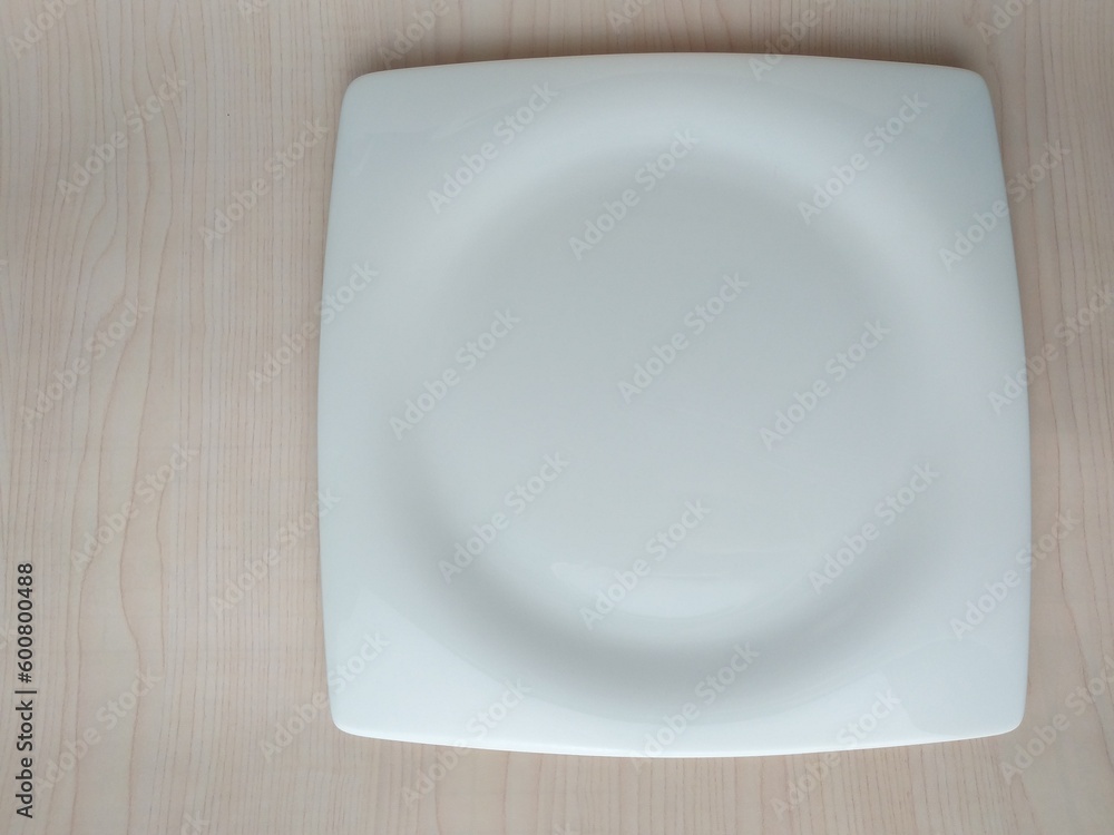 Empty white plate on wooden table. Top view with copy space. Empty white plate on wooden table. Top view with copy space.
