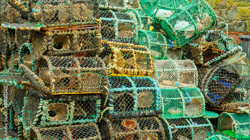 Lobster traps or lobster pots stacked up on the quayside photo