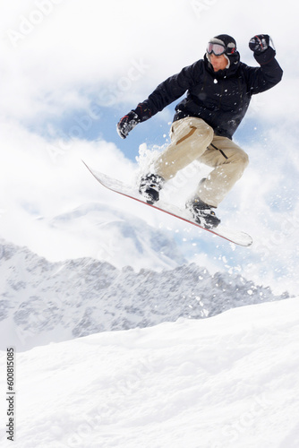 snowboarder taking jump in fresh fallen snow