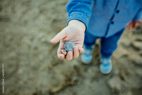 Dłoń małego chłopca trzymającego kamyki i bawiącego się na dworze