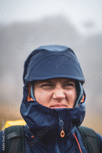 Front view of backpacker in rainproof clothes looking dissatisfied into the distance. Fanal Forest, Madeira Island, Portugal, Europe. Fanal Forest, Madeira Island, Portugal, Europe. © Michael