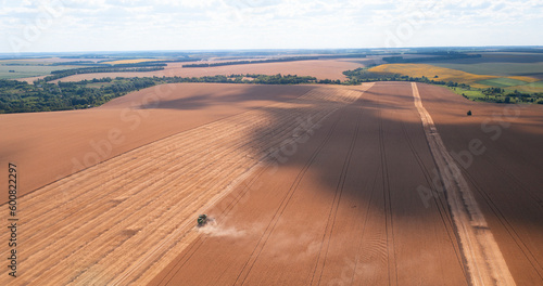 Flying Above: Aerial Shot of Harvesting Wheat Fields with Combine © maykal