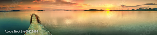 Sunset over the sea. Pier on the foreground. Panorama