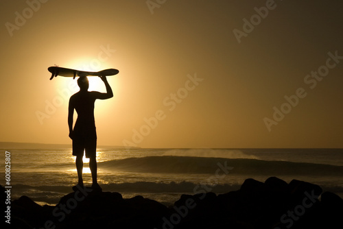 A longboarder watching he waves at sunset in La Santa Lanzarote