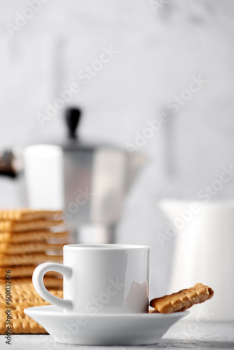 A cup of delicious, freshly brewed coffee with cookies in the background