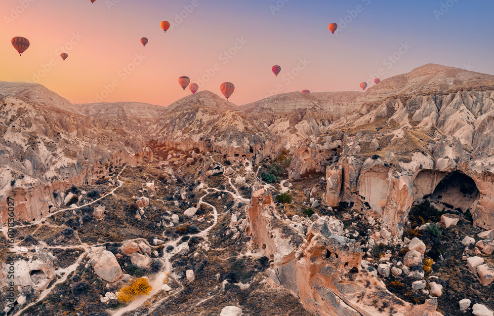 Cave house dwellings of Cappadocia, national park Goreme of Nevsehir Turkey with hot air balloons, aerial drone view