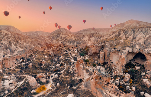 Cave house dwellings of Cappadocia, national park Goreme of Nevsehir Turkey with hot air balloons, aerial drone view