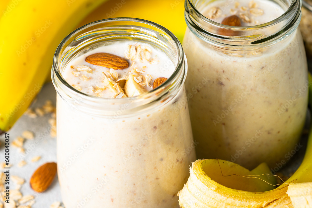 Almond banana smoothie with oat flakes in glass. Close up image. Almond banana smoothie with oat flakes in glass. Close up image.
