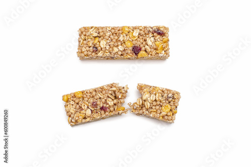 Two muesli bars on a white isolated background. Healthy sweet dessert snack. Cereal muesli with nuts, oatmeal and berries on a white background. One whole and one broken muesli bar