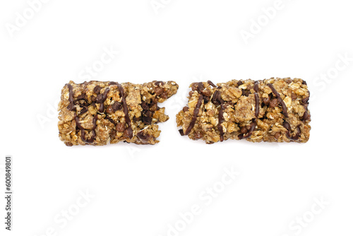 Broken muesli chocolate bar on a white isolated background. Healthy sweet dessert snack. Cereal muesli with nuts, chocolate and berries on a white background. Delicious and healthy dessert