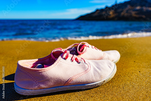 Female sneakers on sand beach photo