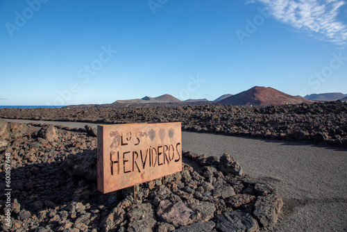 Metal sign of Los Hervideros at rough lava rocks background in timanfaya National Park, Lanzarote, Canary islands