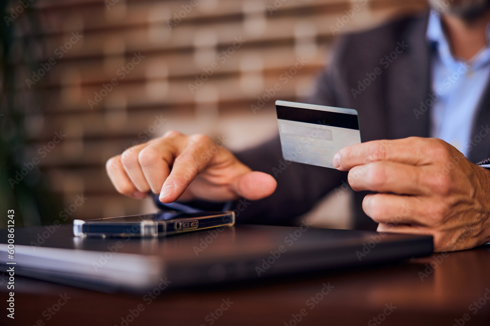 Focus on the male hands, holding a card, paying over the mobile phone. Focus on the male hands, holding a card, paying over the mobile phone.