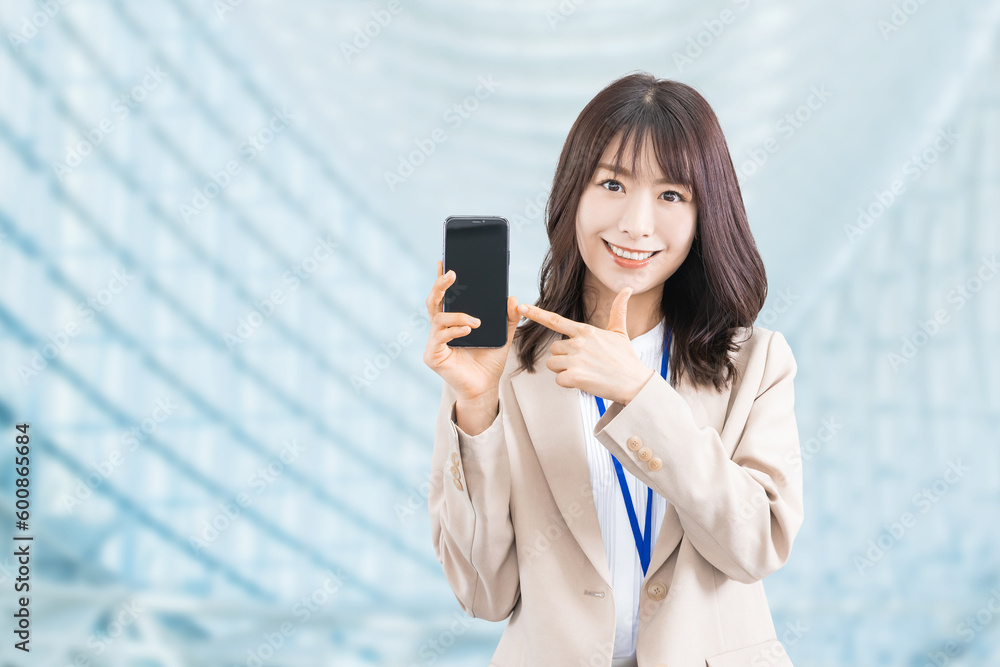 スマホを指差す笑顔の日本人ビジネスウーマン スマホを指差す笑顔の日本人ビジネスウーマン