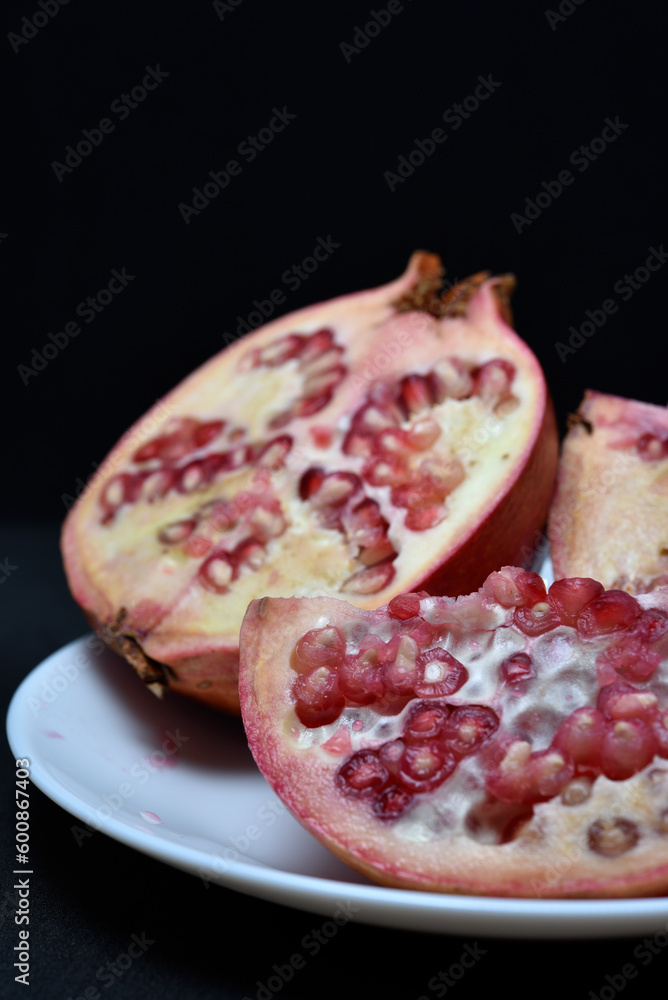 Pomegranate fruit on a white plate. Delicious pomegranate fruit. Cut fruit. Pomegranate fruit on a white plate. Delicious pomegranate fruit. Cut fruit.