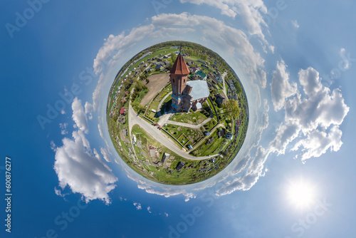 little planet transformation of spherical panorama 360 degrees overlooking church in center of globe in blue sky. Spherical abstract aerial view with curvature of space.