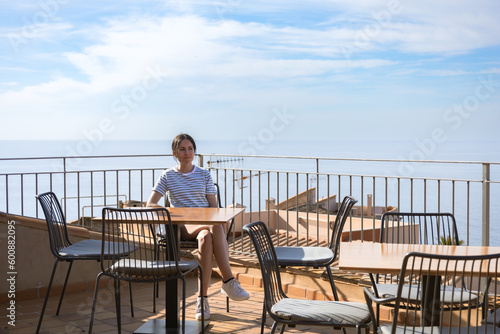 real woman relaxing in a cafe in front of the sea