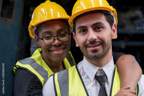 Factory worker and engineer. Male and female worker holding a hat and looking at the camera.