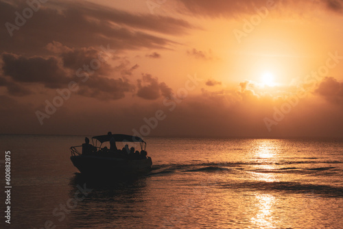 orange sunshine in the sea with a persons on the boat 