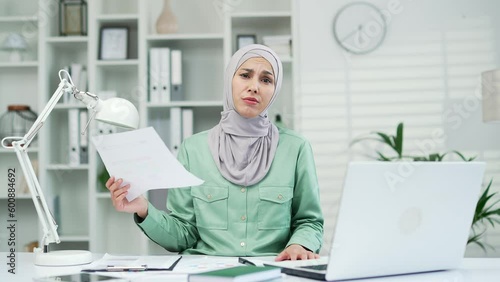 puzzle financier at workplace with paper work young muslim arab woman accountant problems prepares financial repor taxes and finance entrepreneur small business owner is stressed with paperwork photo